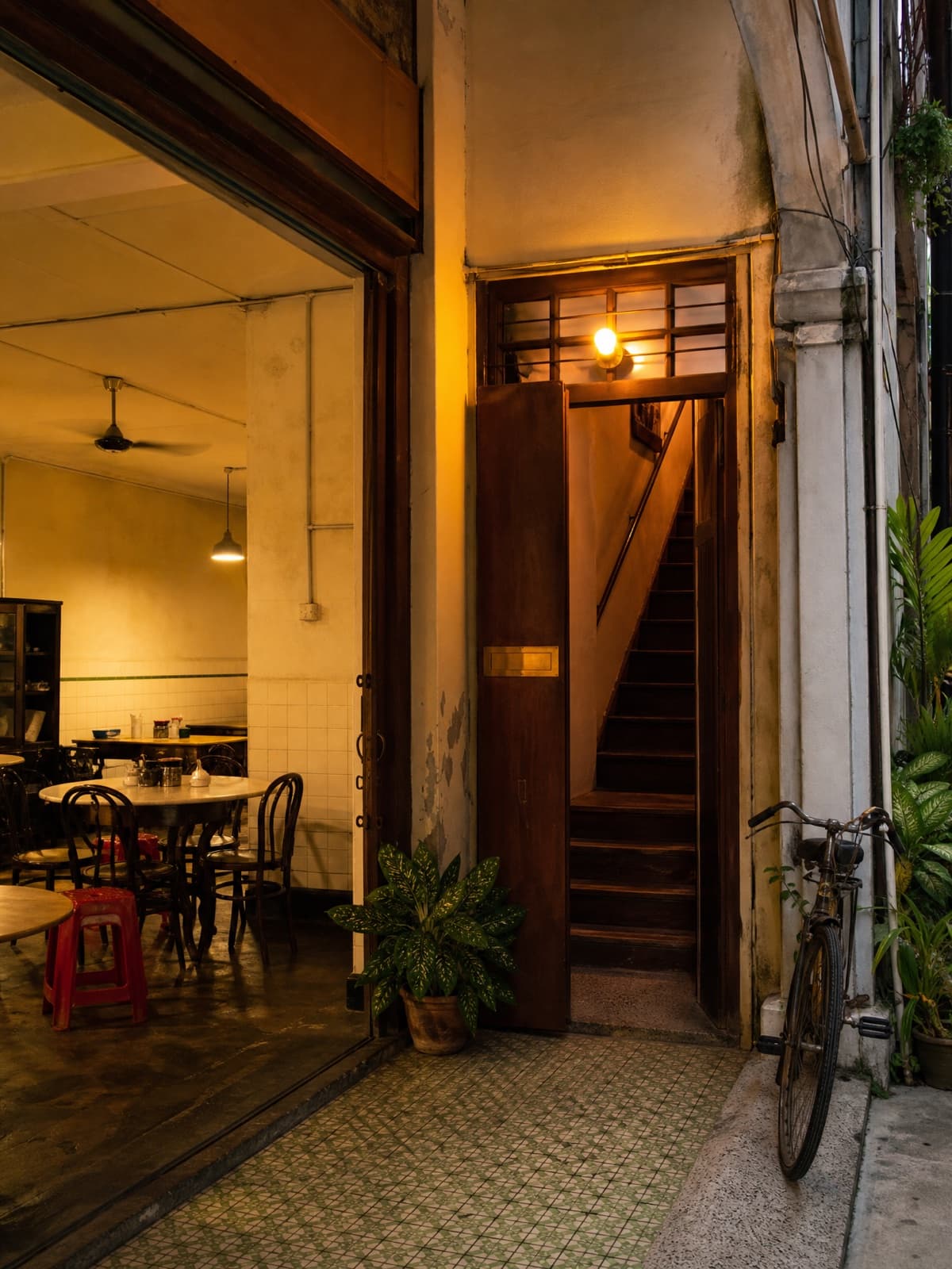 The five-foot-way outside, the kopitiam lit warm and the timber door to the barbershop stairs beside it